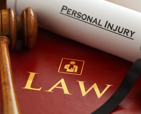 A gavel and scroll of paper that says "Personal Injury"