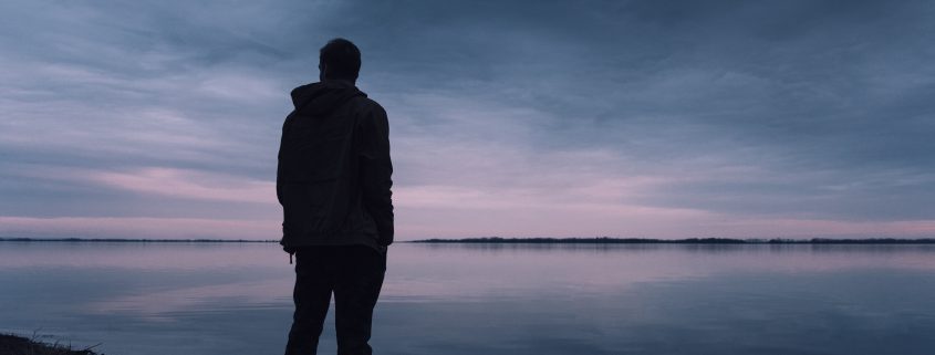 A man standing by a lake