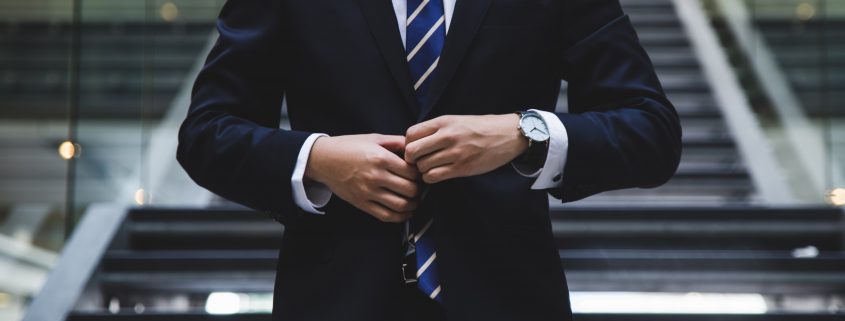 An attorney buttoning a suit jacket