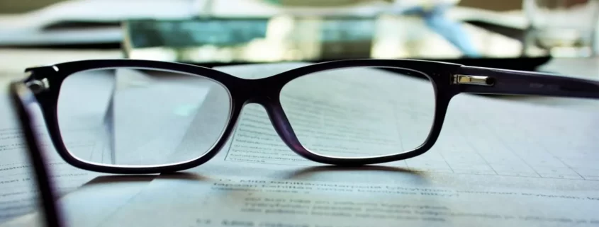 A pair of glasses lying on some documents
