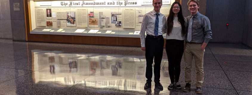 Three Oley Valley students standing together in front of a First Amendment display