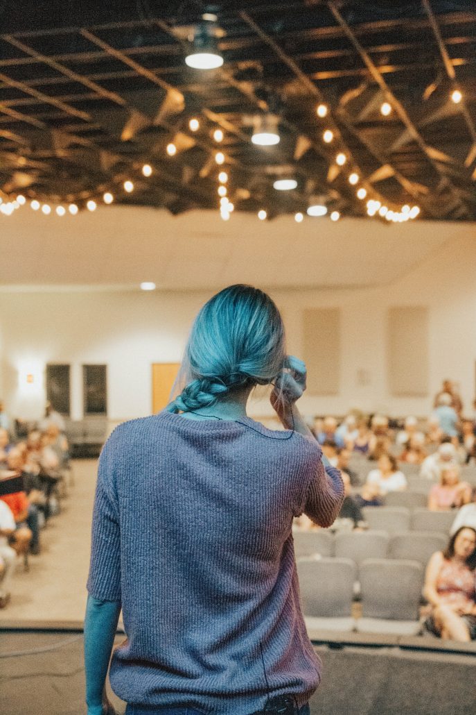 A woman standing in front of an auditorium full of people