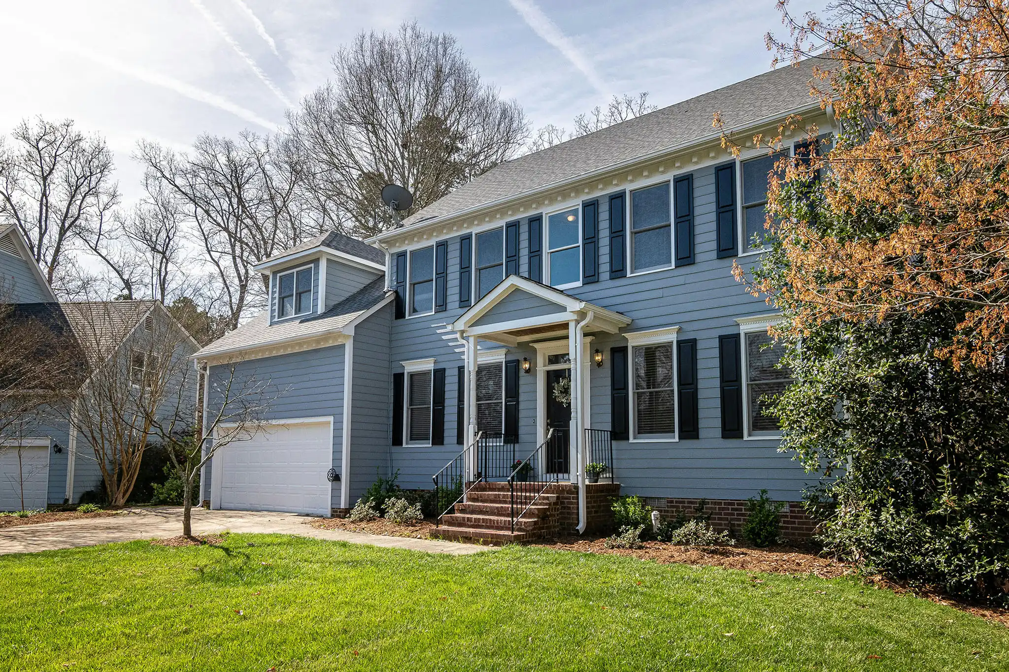 A blue suburban house on a sunny day