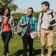 Three college students walking through campus