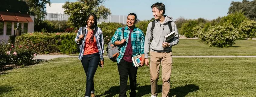 Three college students walking through campus