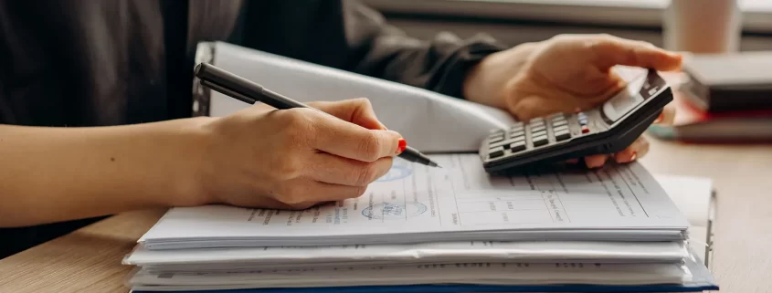 A woman calculating numbers on a document