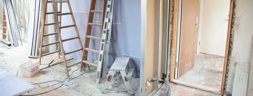 A room in the middle of renovations. Ladders and levels lean against the wall.