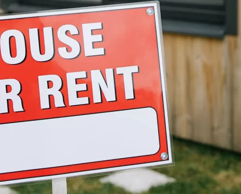 A House For Rent sign outside of a house