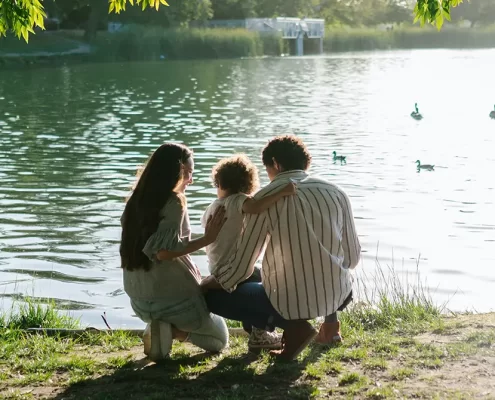 Parents feeding ducks with their adopted stepchild