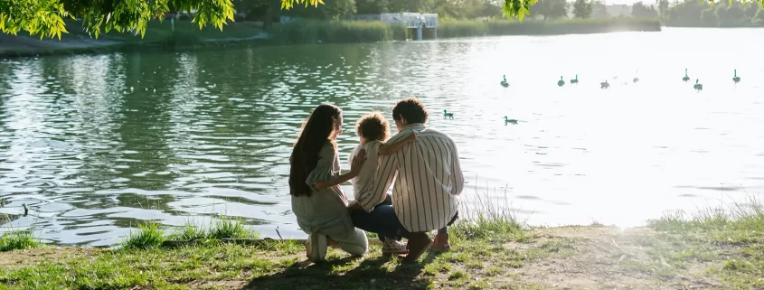 Parents feeding ducks with their adopted stepchild