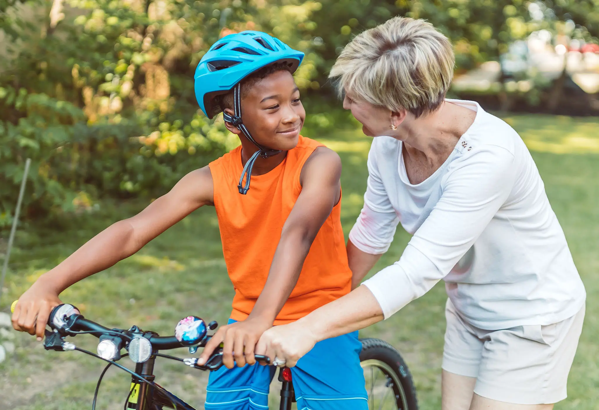 A mother teaching her adopted son how to ride a bicycle