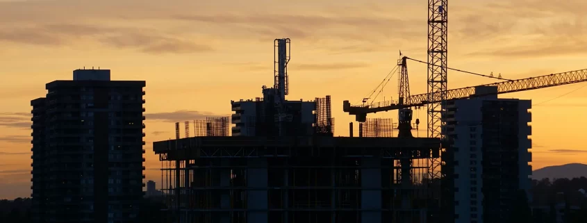 A construction site silhouetted at sunset