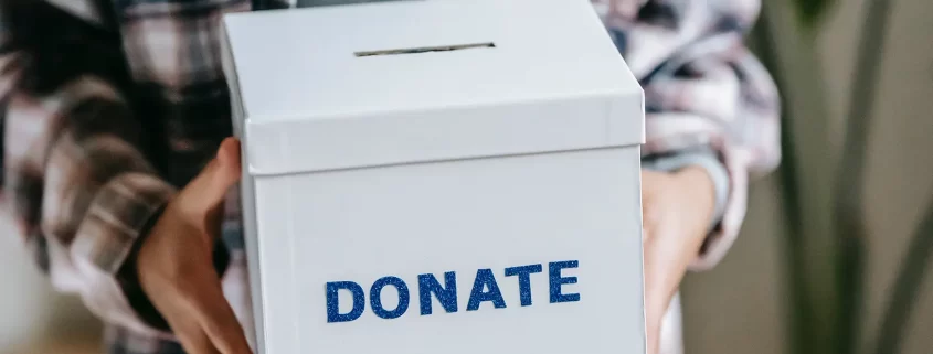 hands holding a nonprofit donation box