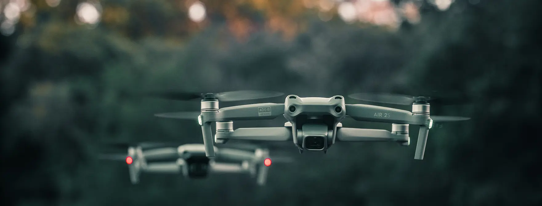 Two drones flying at sunset