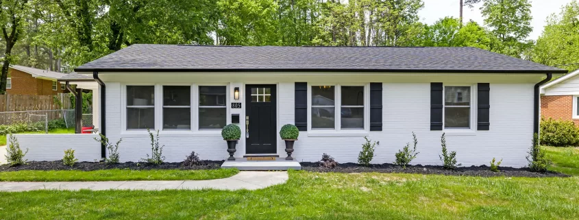 A photo of a small black and white ranch house