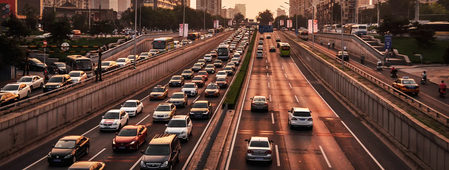 Traffic driving on a busy city highway at sunset