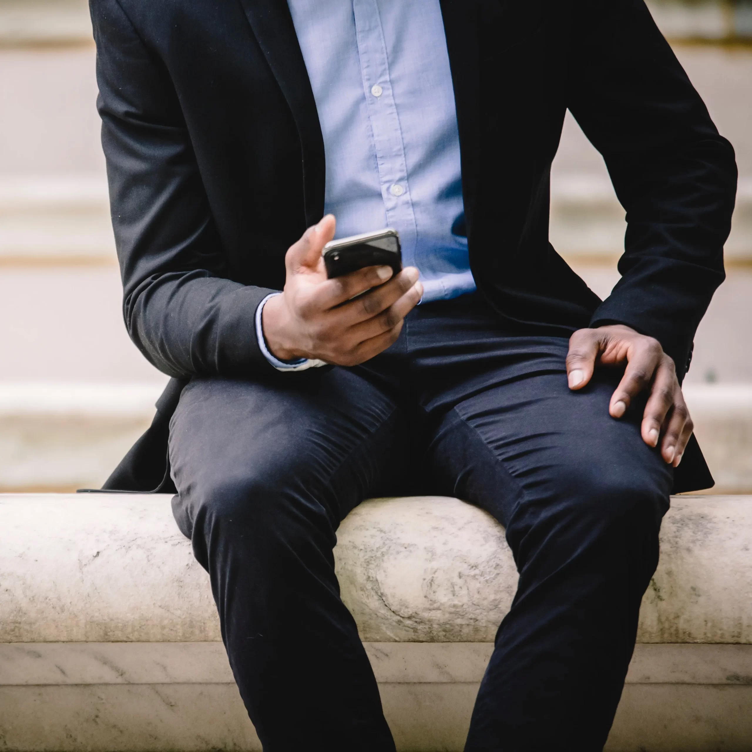 A man in a suit about to make a phone call on his mobile device