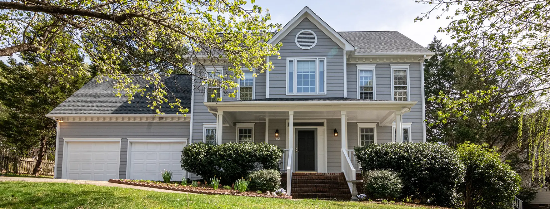 A photo of a gray suburban home on a sunny day.