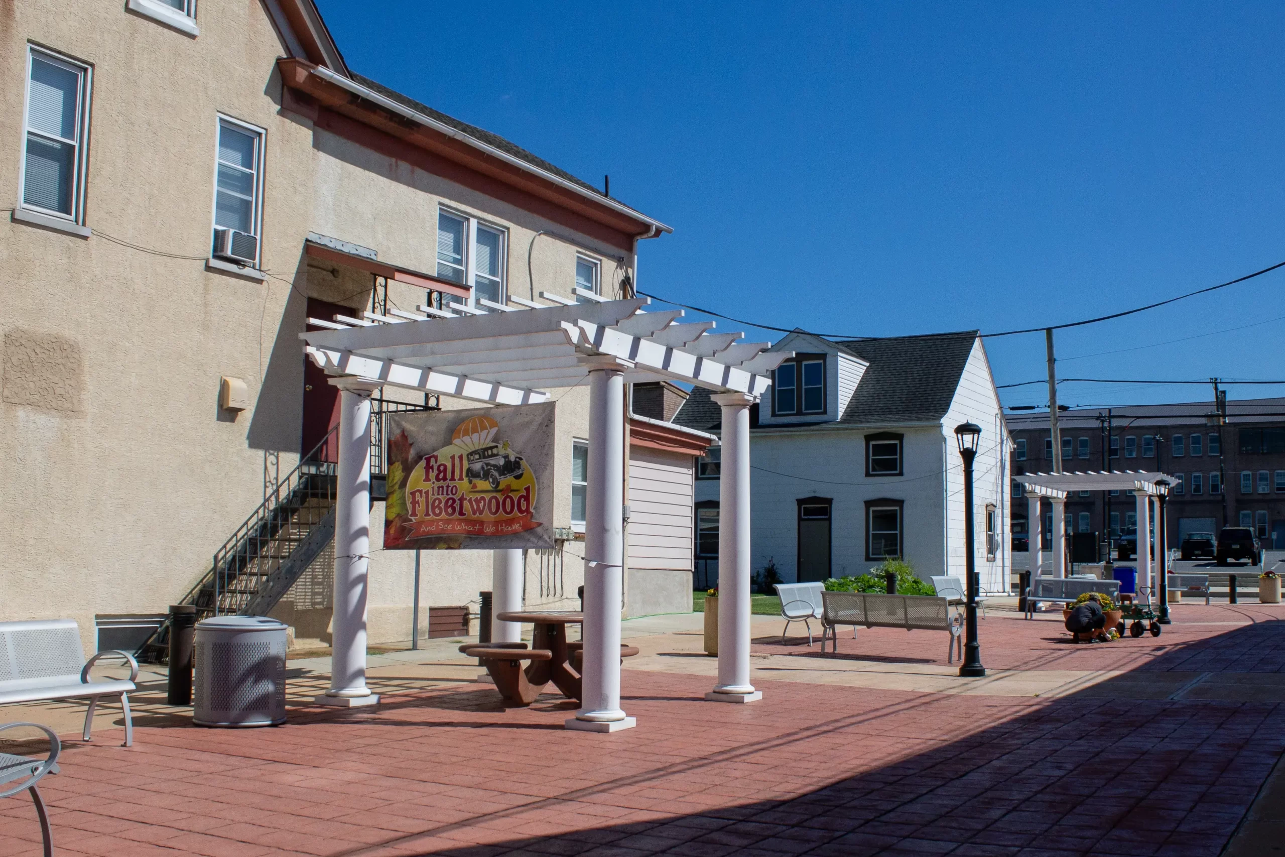 The plaza on Main Street in Fleetwood, with a sign for "Fall into Fleetwood" hanging on the pergola.