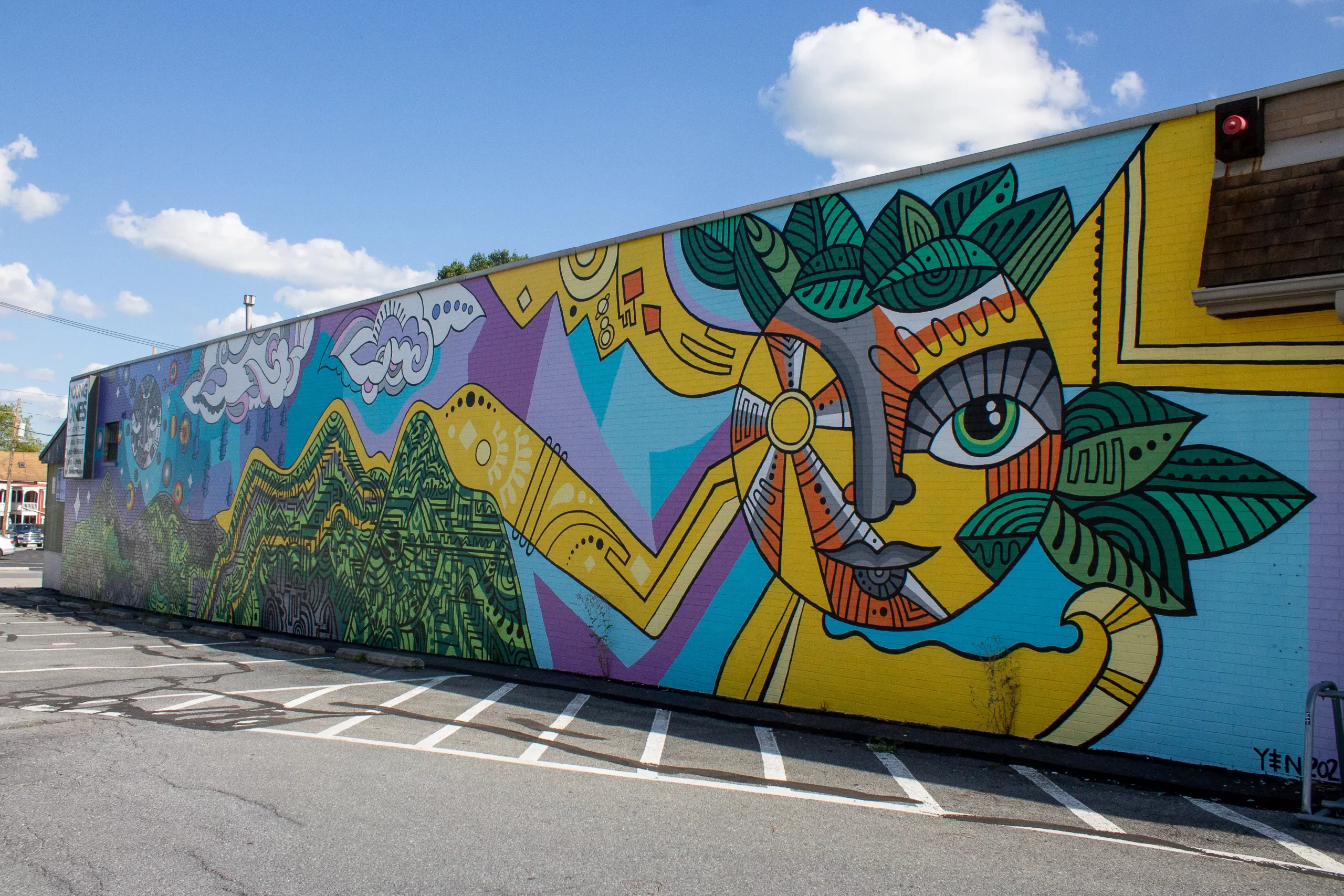 A blue, purple, green, yellow, orange, and gray mural on the side of Young Ones in Kutztown.