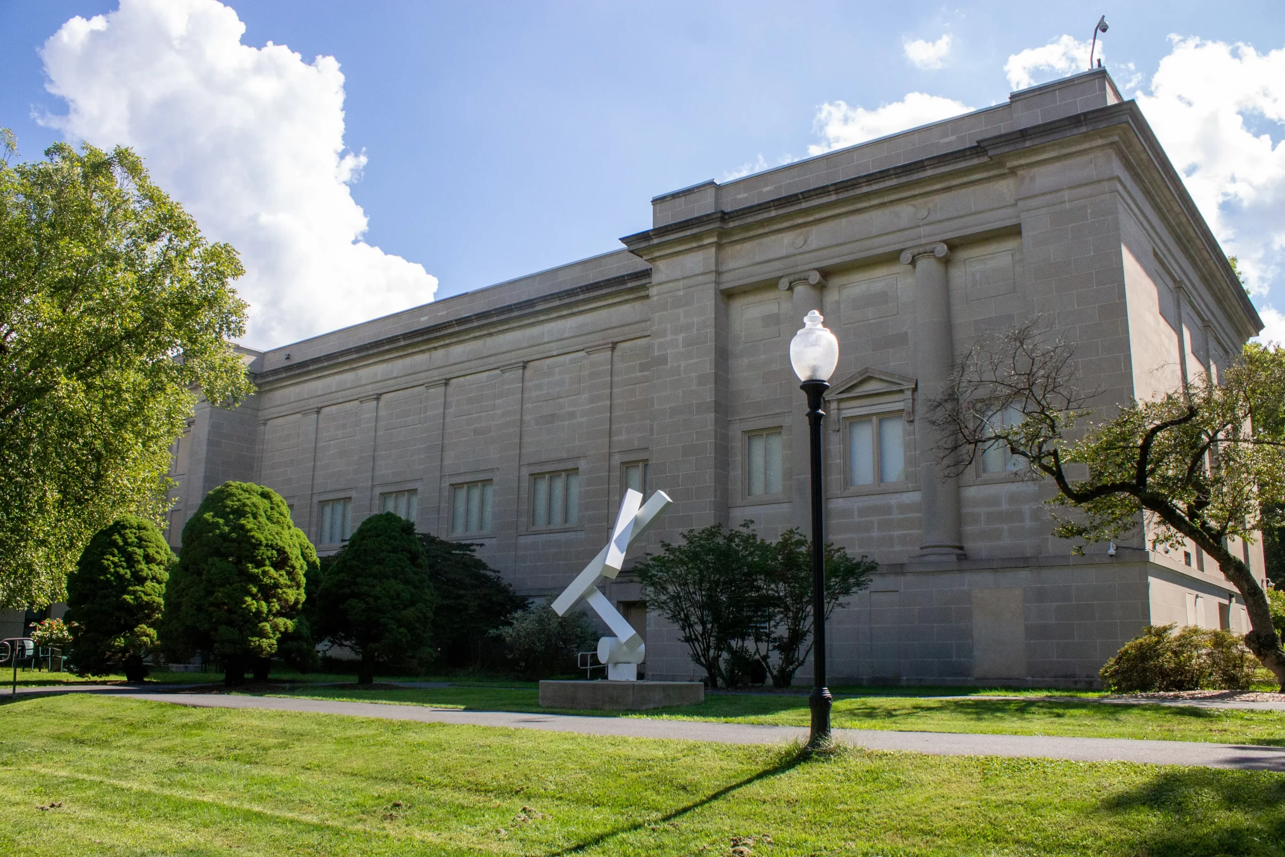 The side of the Reading Museum on a sunny day. A white statue is also featured in front of the building.