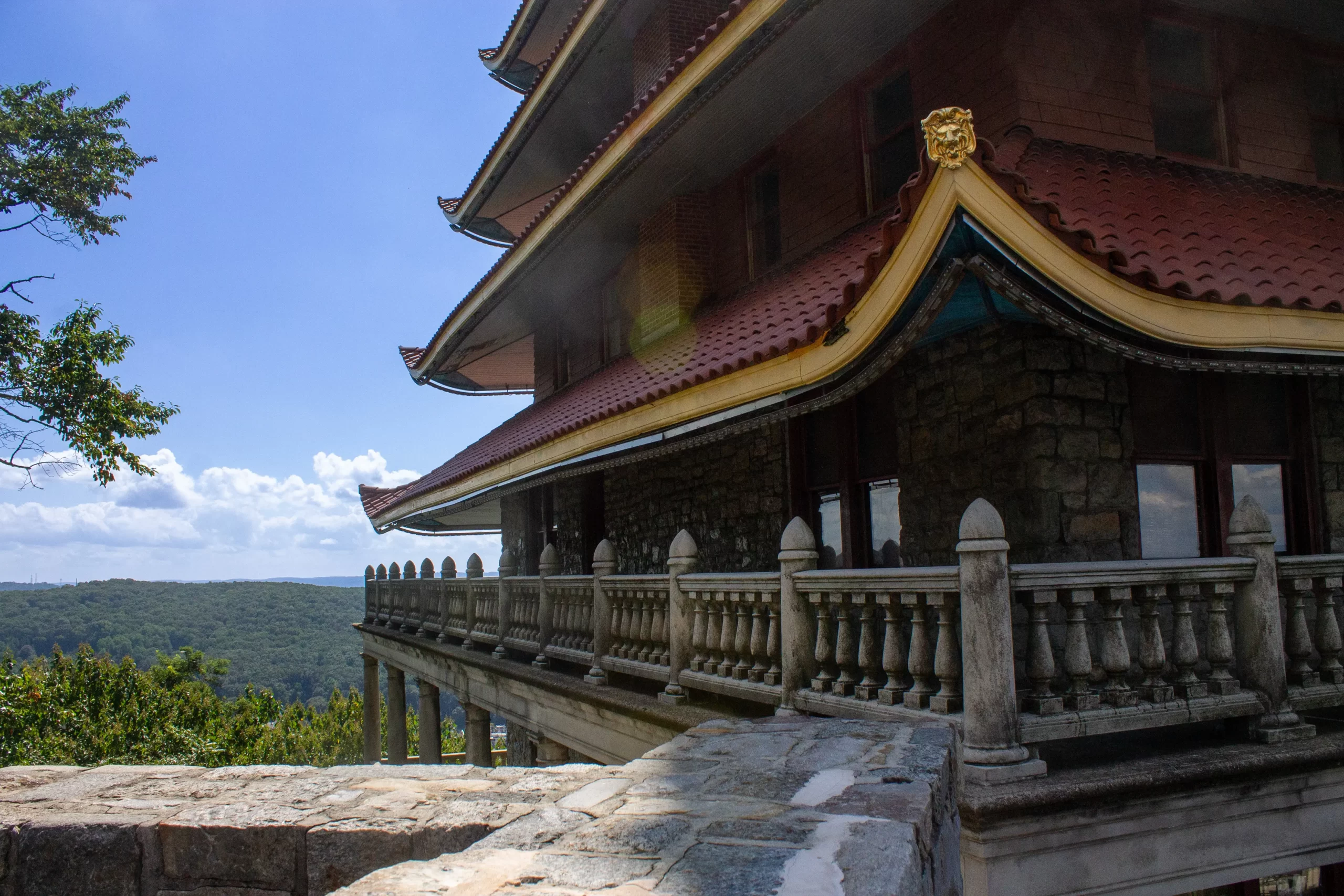 A photo of the Pagoda with some trees, fluffy clouds, and blue sky in the background.