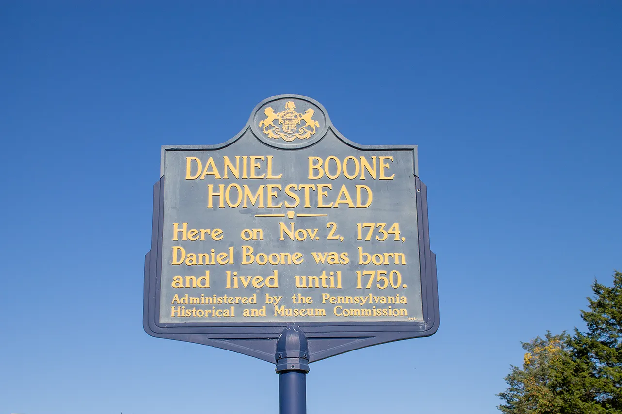 A historical marker for the Daniel Boone Homestead. It reads "Here on Nov. 2 1734, Daniel Boone was born and lived until 1750. Administered by the Pennsylvania Historical and Museum Commission."