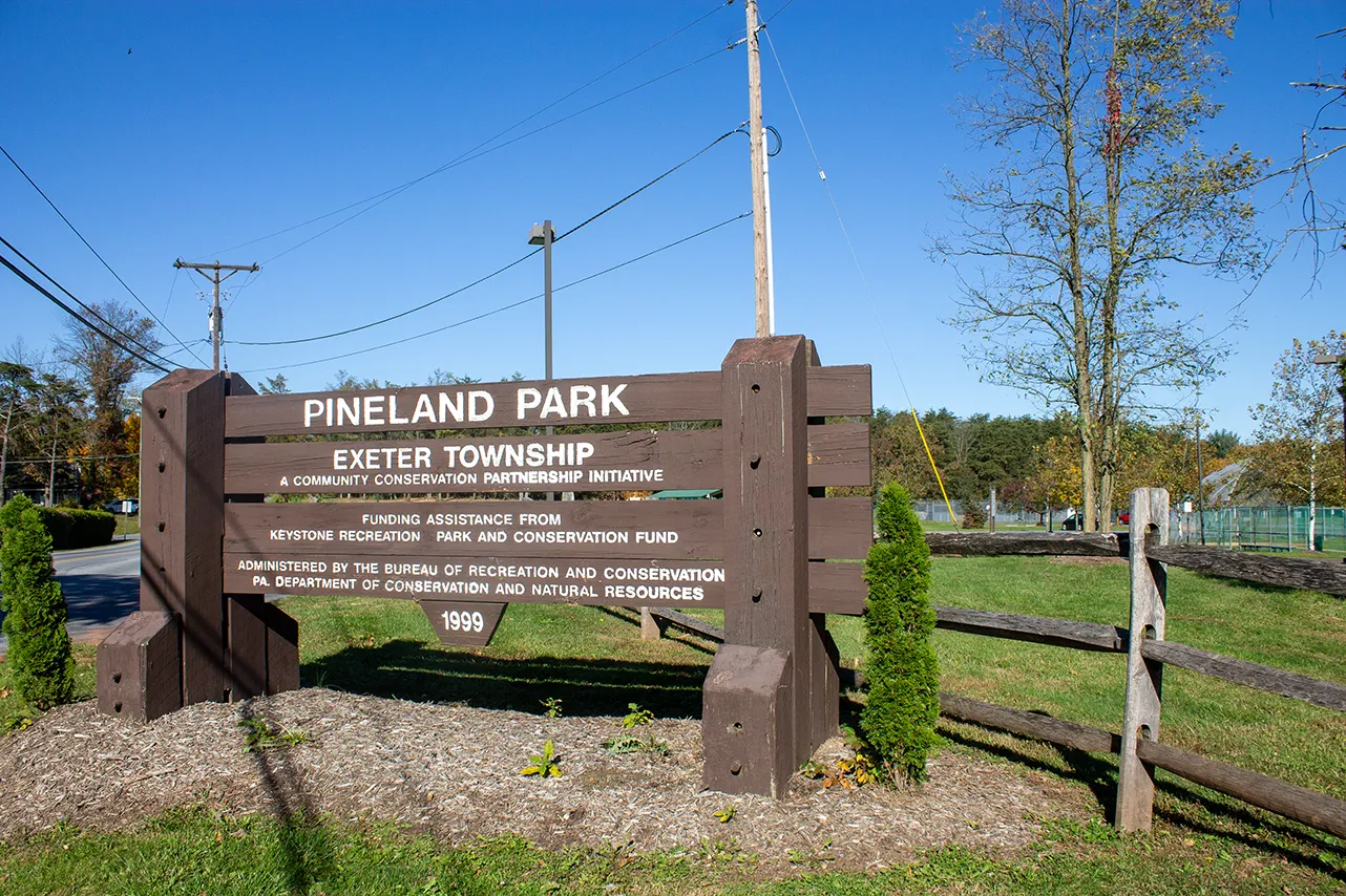 A photo of the Pineland Park sign in Exeter Township on a sunny day