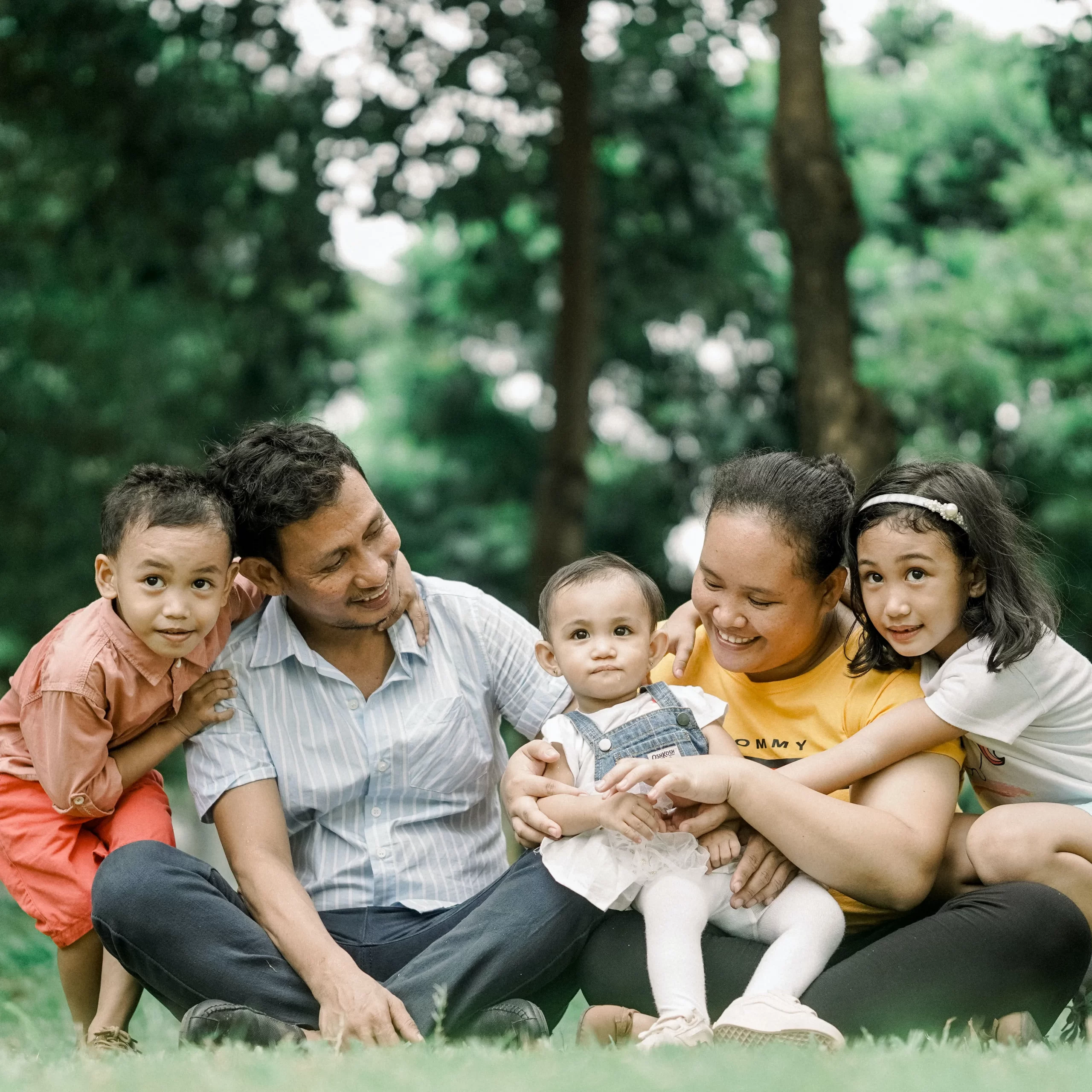 An immigrant couple smiling with their three young children