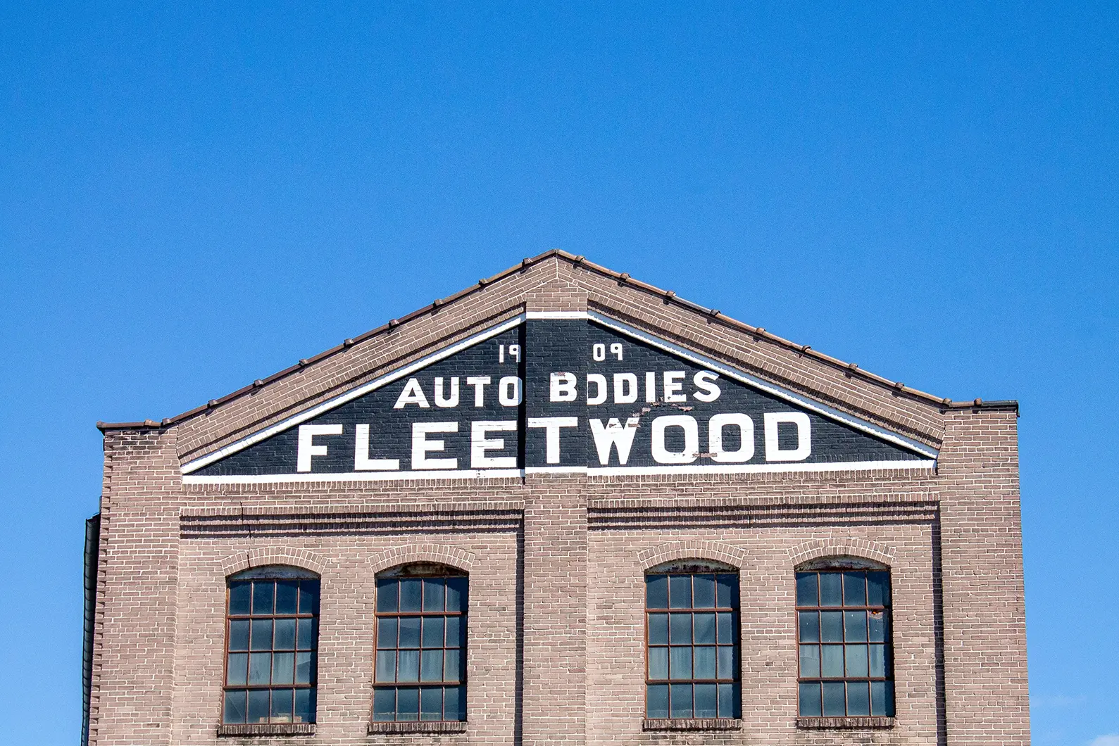 The top of the Fleetwood Auto Bodies building on a sunny day.