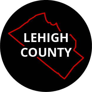 The words "Lehigh County" in a black circle with red outline of the county behind it. The image links to a page listing the county's Magisterial District Courts.