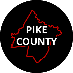 The words "Pike County" in a black circle with red outline of the county behind it. The image links to a page listing the county's Magisterial District Courts.