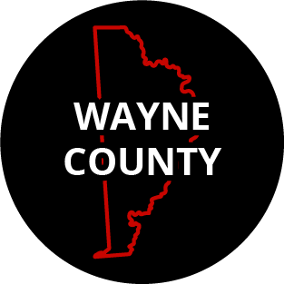 The words "Wayne County" in a black circle with red outline of the county behind it. The image links to a page listing the county's Magisterial District Courts.