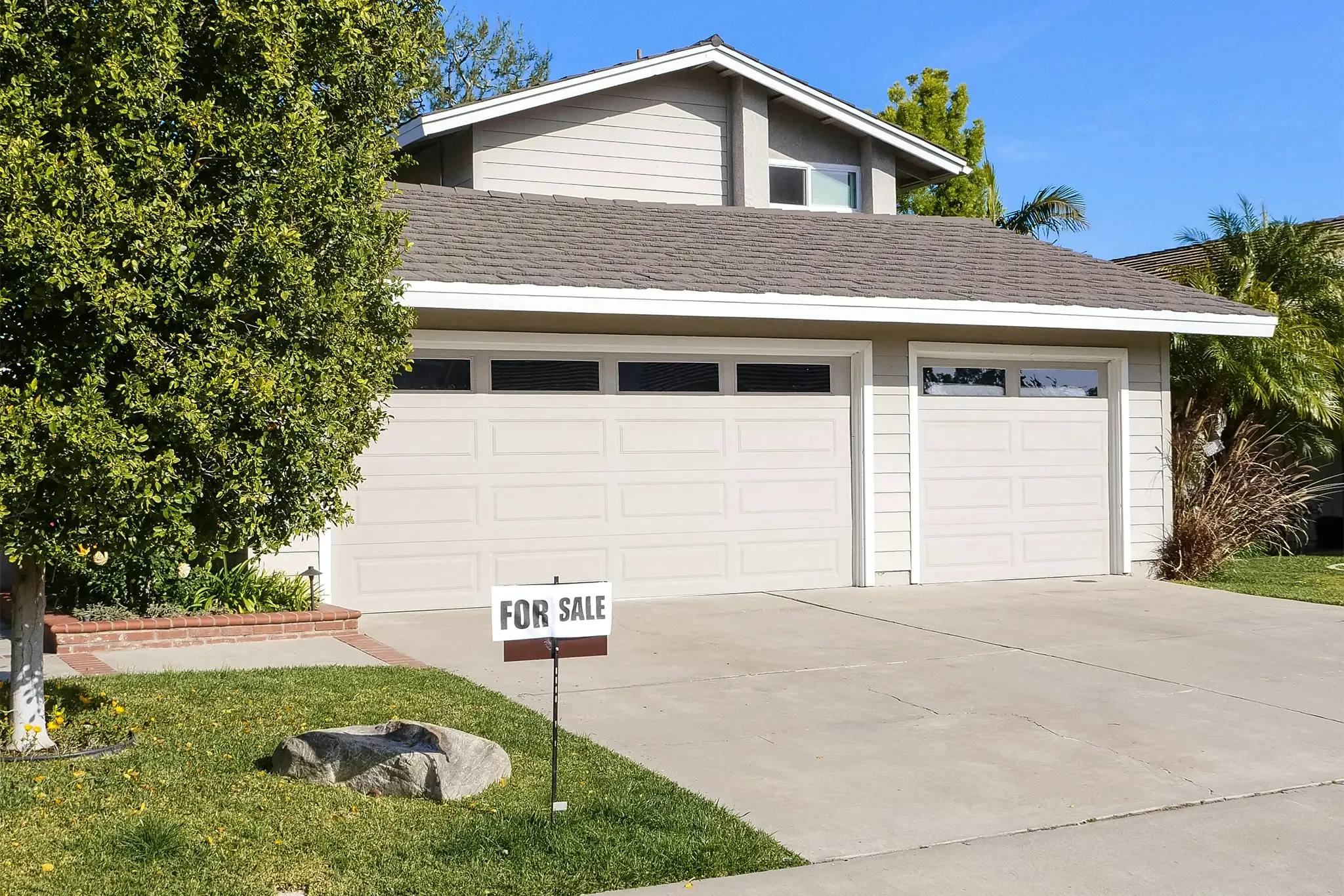 A house with a for sale sign in front of it