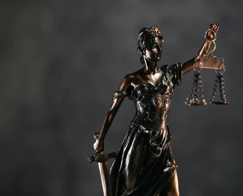 A bronze Lady Justice figure holding scales