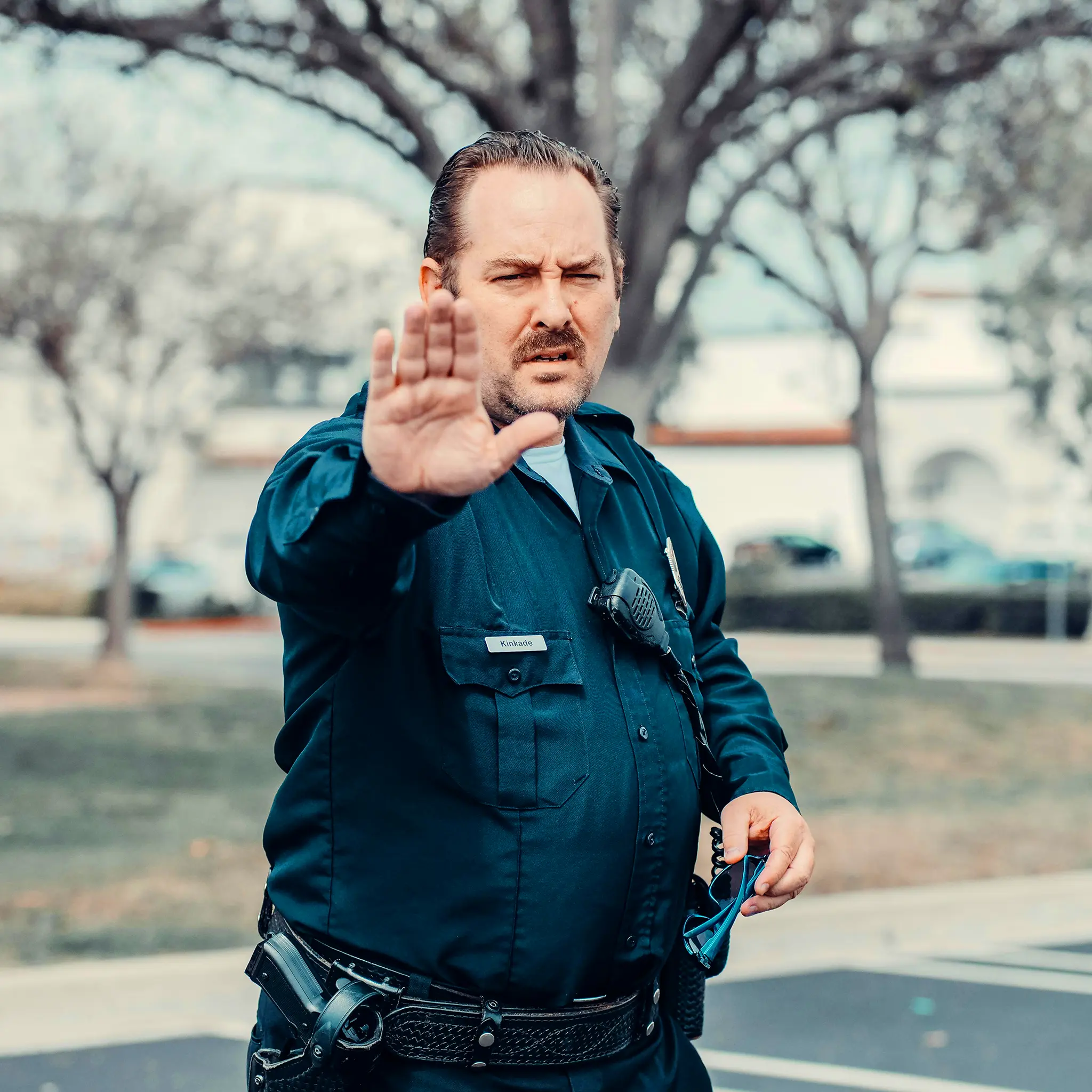 A police officer holding up a hand to stop someone