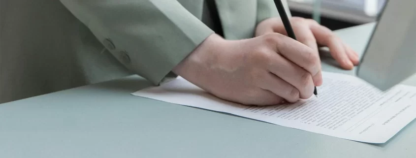 Someone's hand signing a document