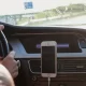 A woman driving with a cell phone mounted to her dashboard.