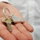 An outstretched hand holding a house key