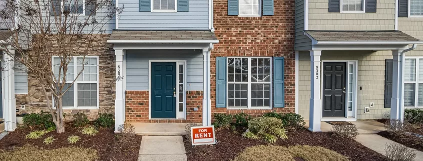 A house with a "for rent" sign in front of it