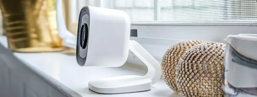 A nanny cam sitting on a shelf by a window