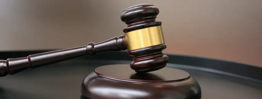 A brown gavel resting on a sound block