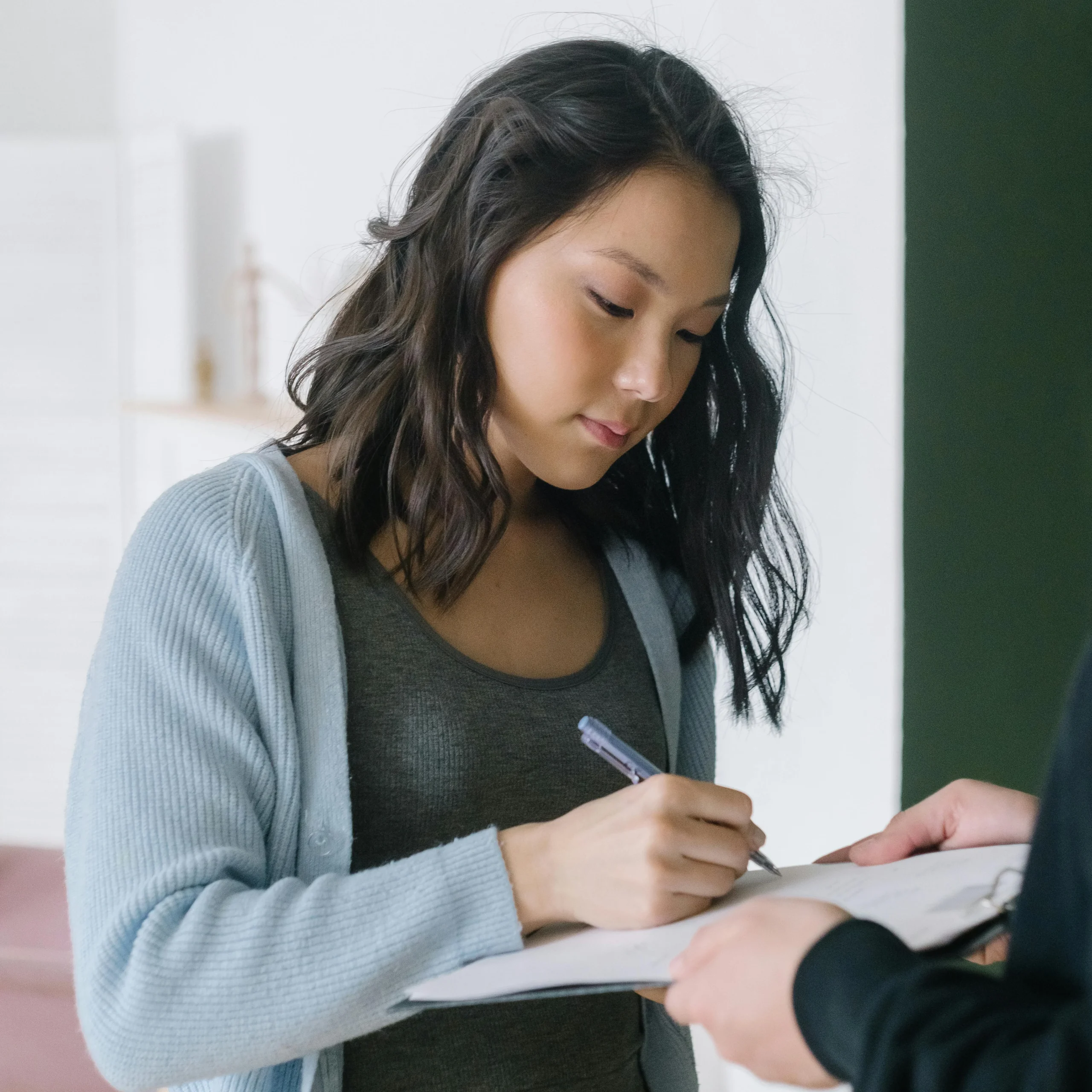 A woman signing a document