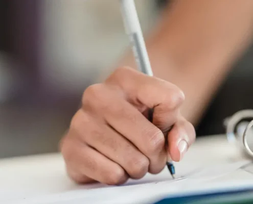 A hand writing on paperwork