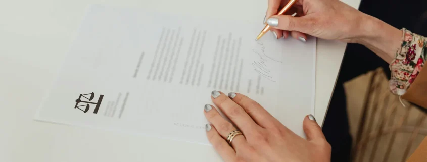 A woman's hands signing a paper