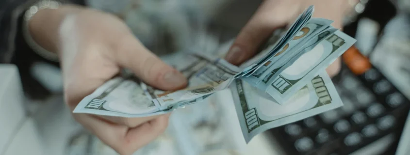 Someone counting a cash security deposit with a calculator nearby