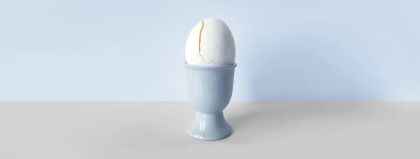 A photo of a cracked egg in an egg holder