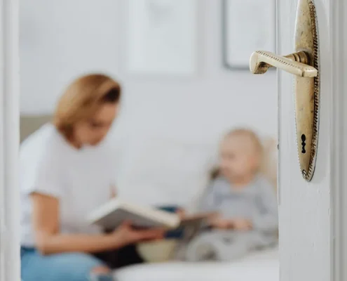A parent visiting with their child and framed by a fancy doorway