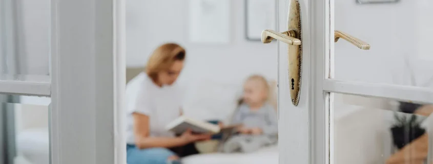 A parent visiting with their child and framed by a fancy doorway